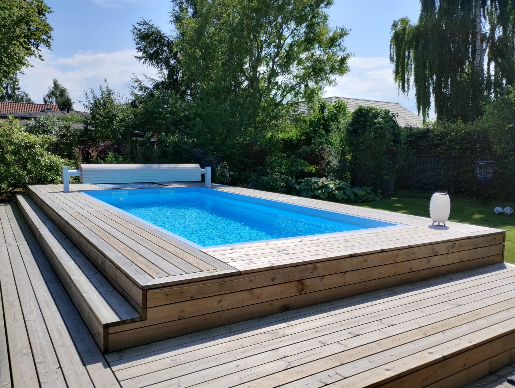 Finished pool with wooden deck in the back garden