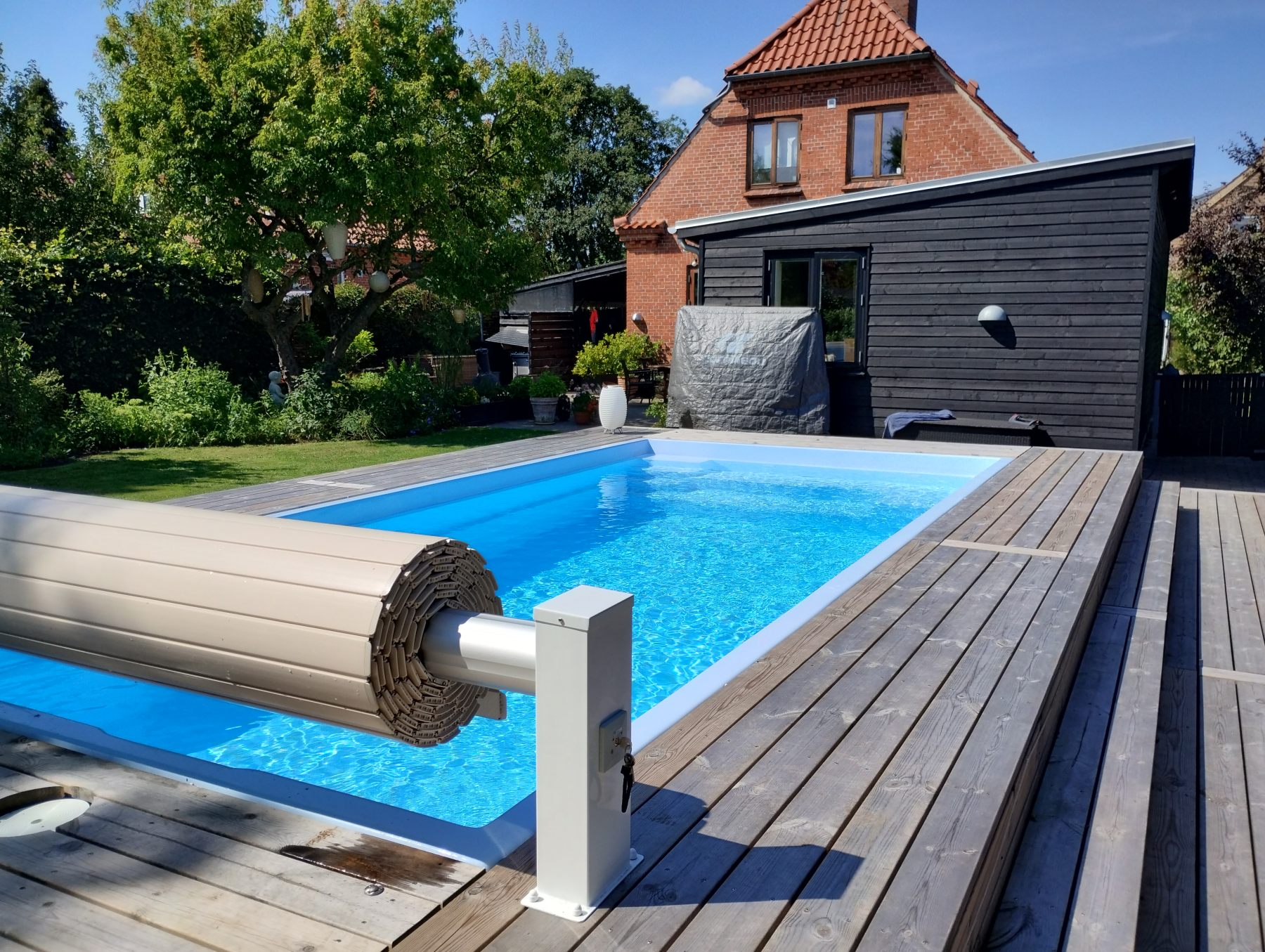 Pool with automatic cover roller
